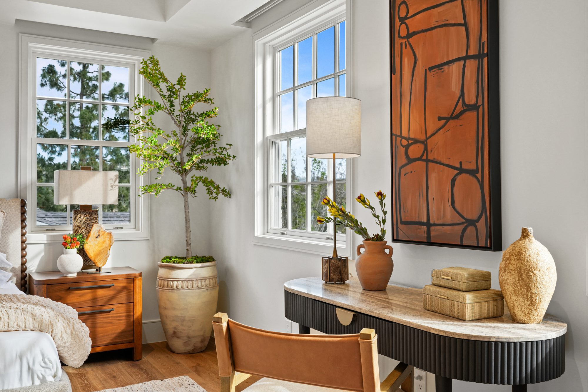 Bedroom corner with walnut nightstand, olive tree and terracotta abstract art
