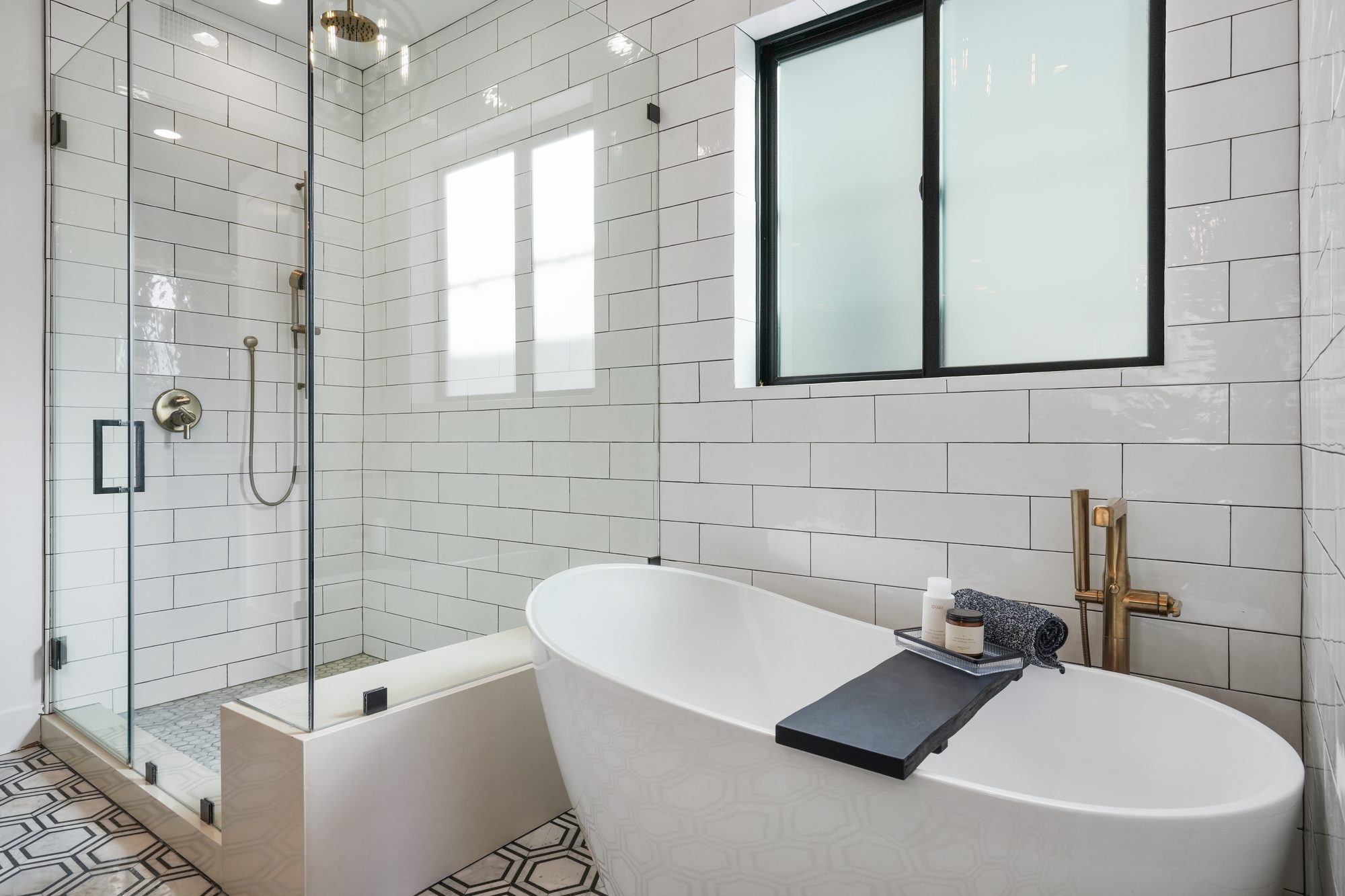 Primary bathroom with freestanding soaking tub, brass fixtures and glass walk-in shower